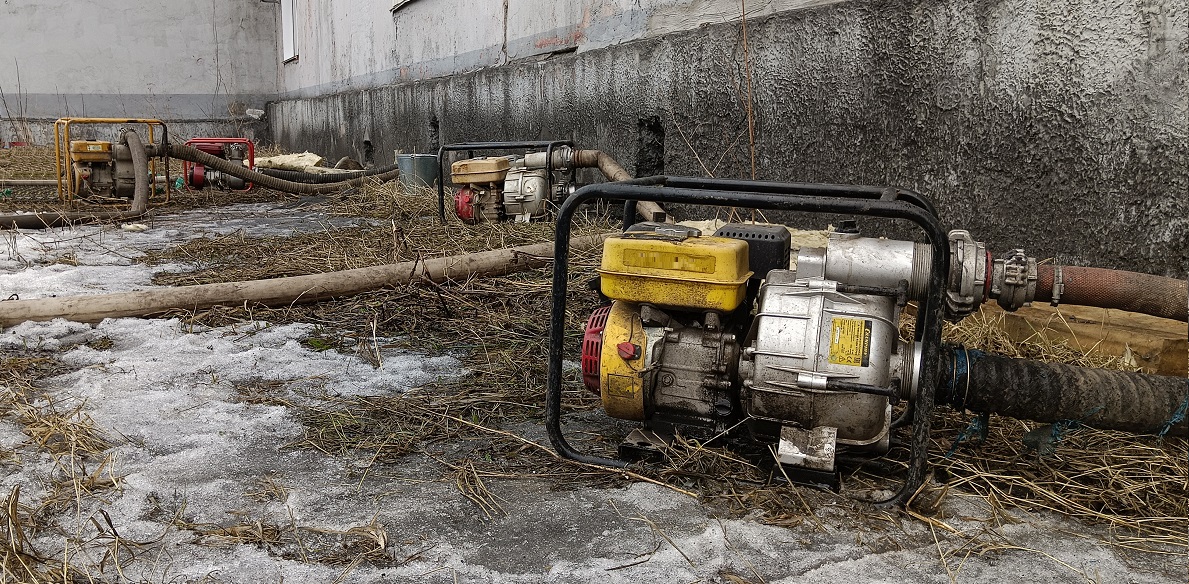 Откачка мотопомпами талой воды из подвала дома в Новгородской области